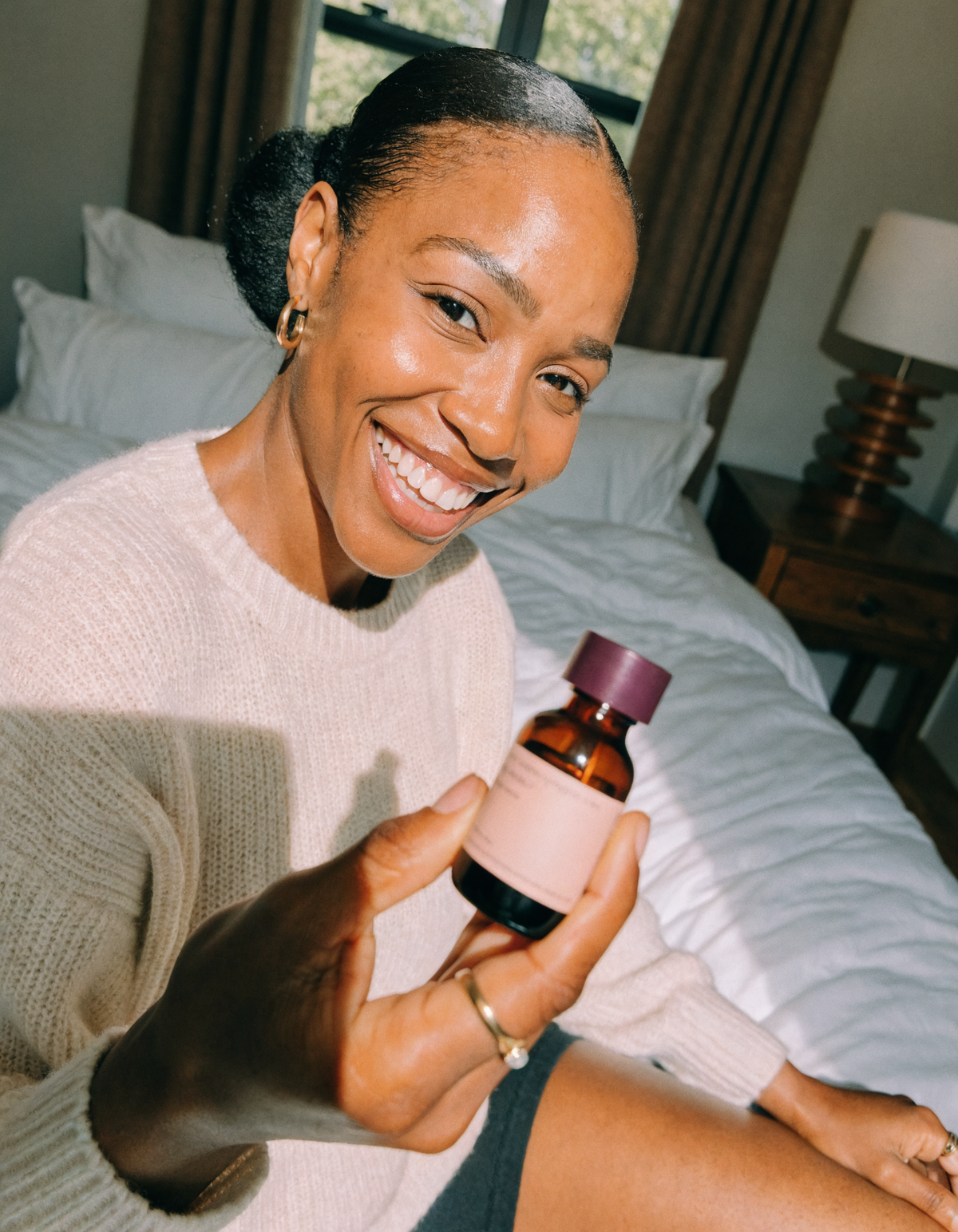 Holding the HueMe™ Hair batana oil bottle